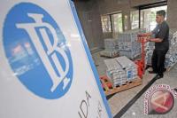 Pekerja bank sedang memindahkan tumpukan uang kertas di Bank Indonesia