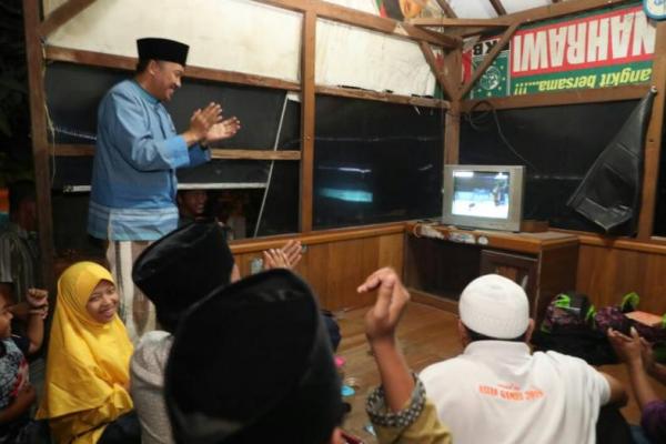 Dengan masih menggunakan sarung dan kopiah usai acara Buka Puasa Bersama dengan IKA UINSA dan warga Kedung Cangkring, Menpora bersama warga duduk di pos ronda untuk menyaksikan laga final Owi/Butet.