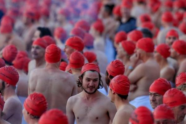 ebanyak 1.020 orang berkumpul saat fajar untuk menandai titik balik matahari musim dingin dengan berenang di sungai Derwent