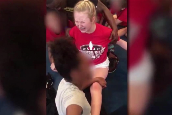 Seorang gadis remaja menjerit kesakitan saat dipaksa melakukan splits oleh pelatih dan rekan timnya.