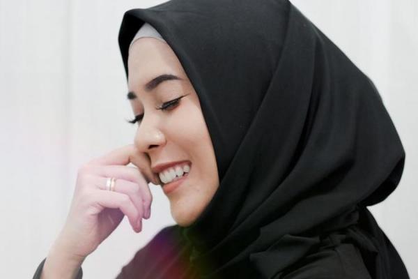 Mengenakan hijab segi empat berwarna hitam, komedian Fitri Tropika tampak anggun dan bersahaja.