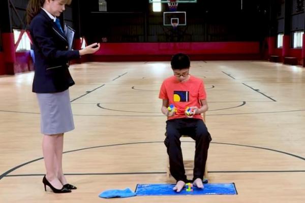 Warga Xiamen Que Jianyu diamati oleh seorang hakim Guinness ketika ia memecahkan tiga kubus Rubik sekaligus, dua di masing-masing tangan dan satu dengan kakinya dalam waktu 1 menit, 36,39 detik.