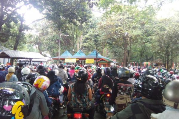 Antusiasme pengunjung yang menggunakan kendaraan mobil dan motor tampak antre saat hendak memasuki Gerbang Utama Taman Margasatwa Ragunan.