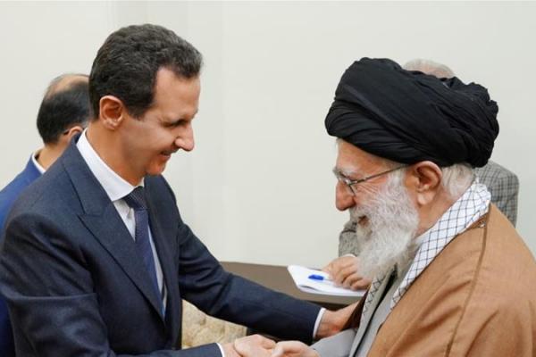 Media Suriah dan Iran merilis foto yang menunjukkan Assad, mengenakan setelan gelap berpelukan dengan Khamenei dan berjabat tangan dengan Rouhani, keduanya tersenyum.