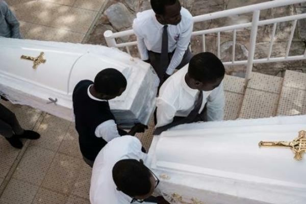 Pelayat menangis ketika 81 peti mati putih berisi sisa-sisa 84.437 korban pembunuhan massal 1994 dimakamkan di Nyanza Genocide Memorial di ibukota.