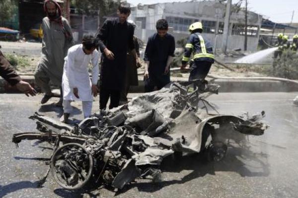 Orang-orang memindahkan reruntuhan mobil setelah ledakan bom di Kabul, Afghanistan, menewaskan sedikitnya empat orang