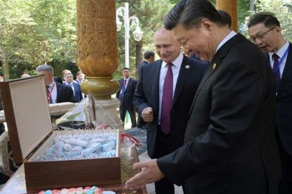 Belum jelas apakah Xi memakan kue pemberian Putin itu atau tidak.
