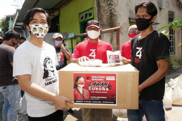 Gibran Rakabuming Raka (33) selaku kader PDI Perjuangan bersama para relawan menyalurkan bantuan 6000 masker non medis dan 2000 masker medis dari Ketua DPR Puan Maharani ke masyarakat Solo, Senin (11/5).