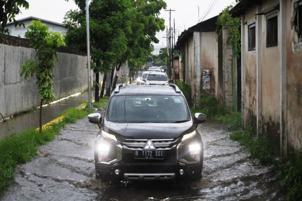 Berkendara di tengah guyuran hujan memerlukan kewaspadaan ekstra, apalagi ketika jalanan yang dilewati terhalang oleh genangan air
